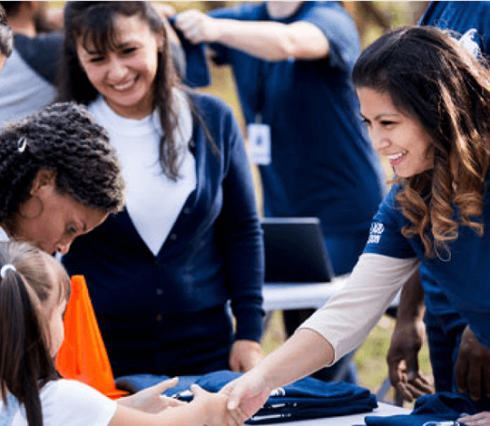 Woman shaking hands with a girl at a nonprofit event