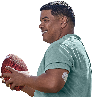 Man playing football and wearing Dexcom G7 sensor on back of the arm
