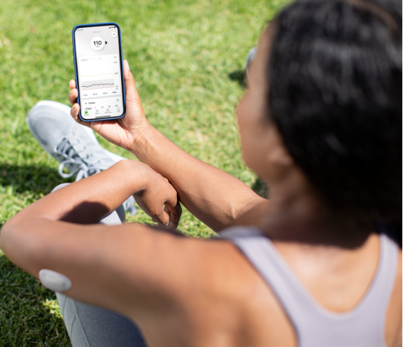 dexcom-g7-lifestyle-photography-woman-excersizing-looking-at-app-ios-mgdl