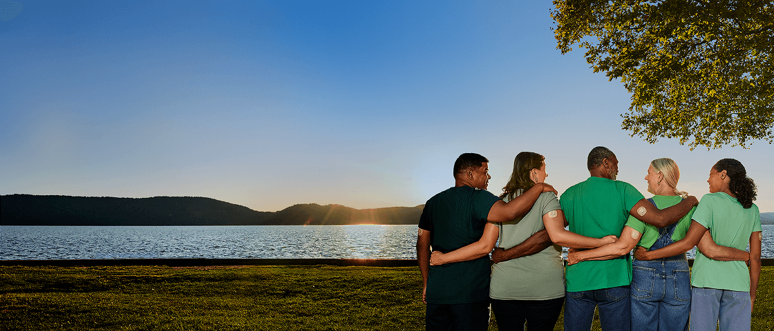 Five people embracing outside, wearing Dexcom G7 15 Day sensor.