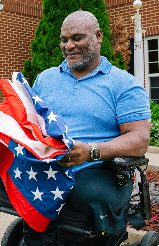 Veterin holding the american flag while wearing the Dexcom G7 15 day sensor